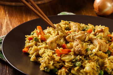 Fried rice nasi goreng with chicken and vegetables on a plate