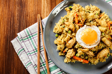 Fried rice nasi goreng with chicken egg and vegetables on a plat