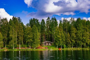 Wooden sauna log cabin at the lake in summer in Finland