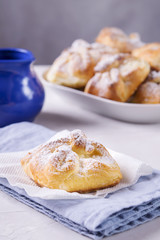 Homemade hungarian Cheese Puff Pastry Parcels. Cottage cheese puffs (buns, patties, cheesecakes) with raisins on light grey concrete background. Selective focus 