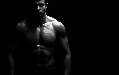 Cropped horizontal monochrome studio shot of a muscular athletic man posing shirtless copyspace...