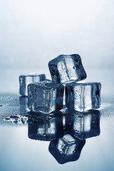 Group of blue wet ice cube with reflection