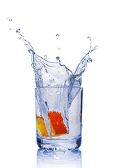 Splash in glass of blue water with orange slice