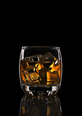 Glass of scotch whiskey with ice cube