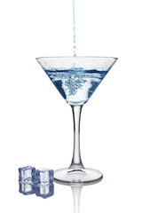 Blue splash in glass of white transparent alcoholic cocktail drink with ice cube