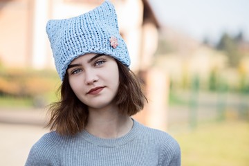 Portrait of young hipster girl in grey wool cap