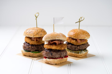 Small beef sliders grilled burgers onion rings little buns bacon served as appetisers for sharing 
