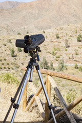 telescopio terrestre montado sobre trípode para observar las aves que pasan por el campo.