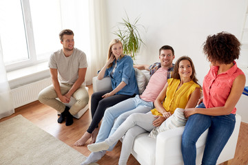 group of happy friends talking at home