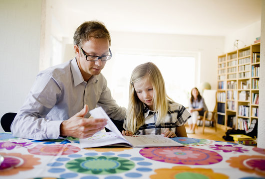 Father helping daughter with homework