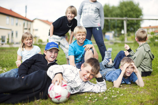 Happy schoolchildren with soccer balls at yard