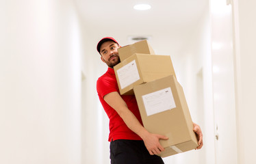 delivery man with parcel boxes in corridor