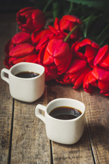 Coffee in a cup and tulips on a table