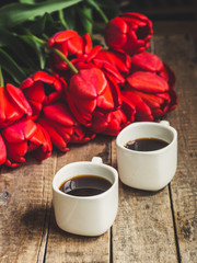 Coffee in a cup and tulips on a table
