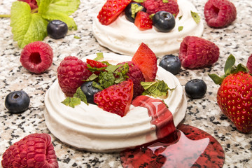 pavlova with fresh sliced, sugared fruit and lemon mint