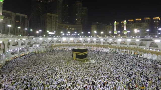 Time lapse video of Muslim pilgrims circling around the holy Kaaba at night during Hajj inside al Masjid al Haram in Mecca, Saudi Arabia. Camera zooms in through the Kaaba.