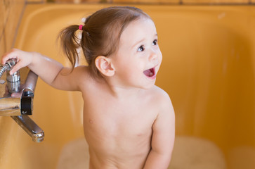Bath time.Happy little girl enjoying bath with spume
