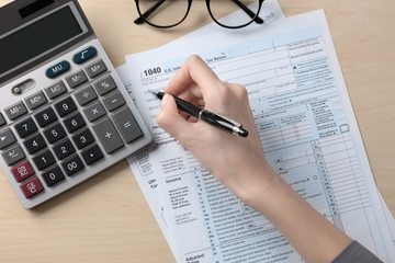 Woman filling in individual income tax form, closeup