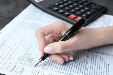 Woman filling in individual income tax form, closeup