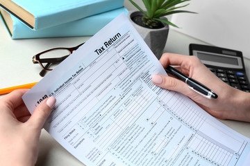 Woman holding individual income tax form, closeup