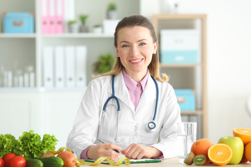 Young female nutritionist working in her office