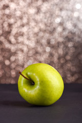 fresh green apple on grey table, sparkling background