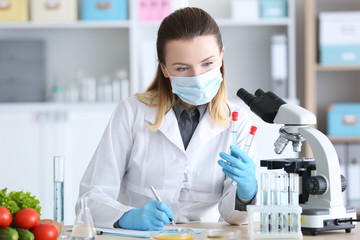 Young female nutritionist testing food samples in laboratory