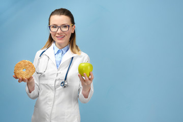 Young female nutritionist on light color background