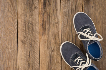 Jeans sneakers on a wooden background.