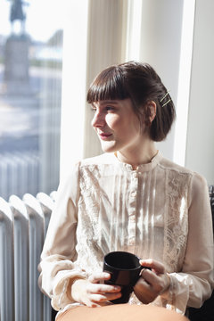 Young businesswoman sitting with coffee cup at cafe