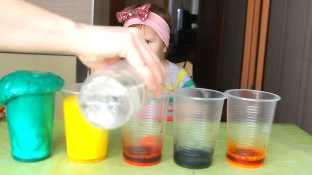 A little girl is experimenting and surprised.