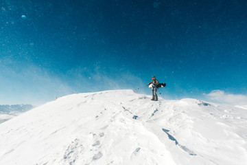 Naklejka na ściany i meble snowboarder is standing on the snow hill
