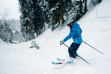 girl with special ski equipment is riding and jumping very fast in the mountain forest