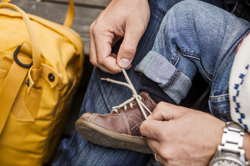 Cropped image of father tying shoelace of baby girl at park