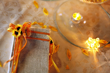 Libro degli ospiti decorato con fiocchi e girasoli, vicino a candela sopra un tavolo