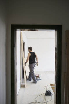 Rear view of worker walking in corridor at home