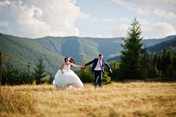 Fototapeta premium Lovely wedding couple at amazing landscapes of Carpathian mountains.