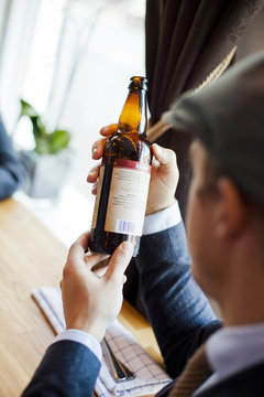 Cropped image of man holding beer bottle in restaurant