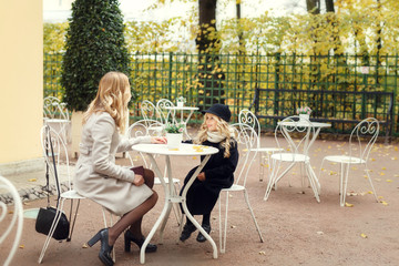 Mom and her daughter at open air cafe