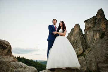 Lovely wedding couple against rocks of fortess Tustan at Carpathian mountains.