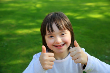 Down syndrome girl smiling in the park
