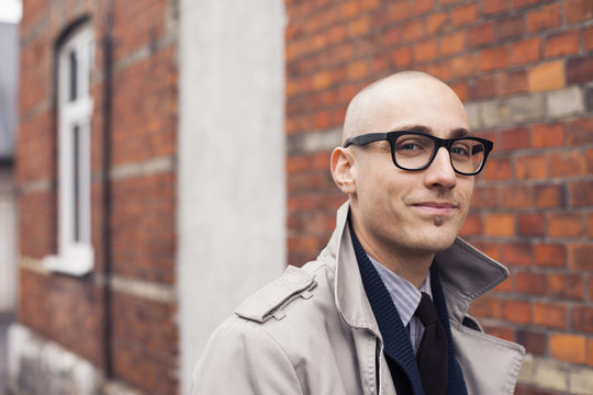 Portrait of confident man by brick wall