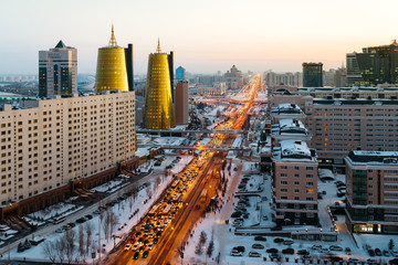 View from above on a large avenue that goes to the horizon, a golden skyscraper and a house of ministries in Astana, Kazakhstan