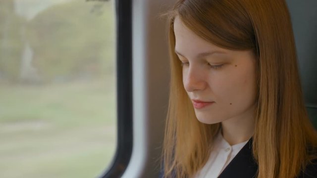 Close Up to the Smiling Face of Young Business Lady while Working on Laptop during the Official Journey by Train