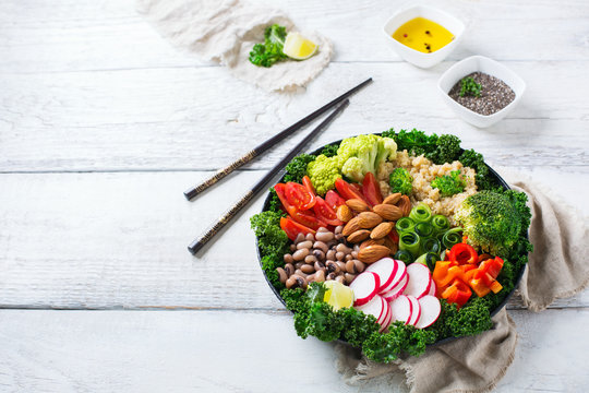 Healthy vegan buddha bowl with kale leaves and raw vegetables