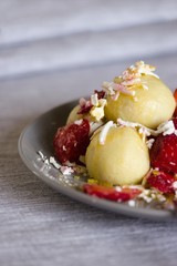 Traditional czech dish. Quark dough dumplings with fruit filling, These are with strawberries. Topped with grated quark,powdered sugar,sliced strawberries and melted butter.