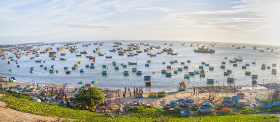 Mui Ne, Vietnam - February 19th, 2017: Fishing village and traditional Vietnamese fishing boats with hundreds of boats moored in a line beautifully. This is the bay for boat storm in central Vietnam