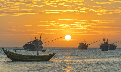 Fototapeta premium Mui Ne, Vietnam - February 19th, 2017: Vietnamese fishing village, Landscape sunset with sea and traditional colorful fishing boats in Mui Ne, Vietnam