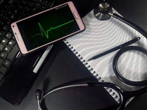 Medical concept. Stethoscope, pen, laptop and smartphone with ecg graph