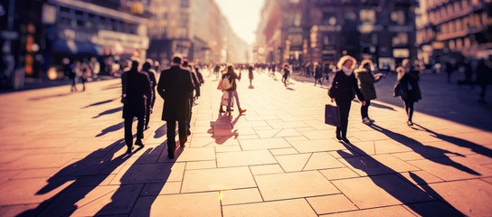 Crowd of anonymous people walking on busy city street